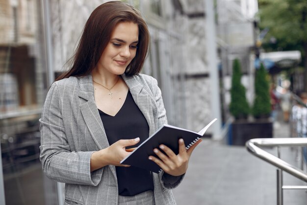 Elegante empresaria que trabaja en una ciudad y usa el cuaderno