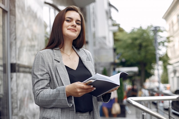 Elegante empresaria que trabaja en una ciudad y usa el cuaderno