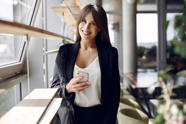 Elegante empresaria trabajando en una oficina y usar el teléfono