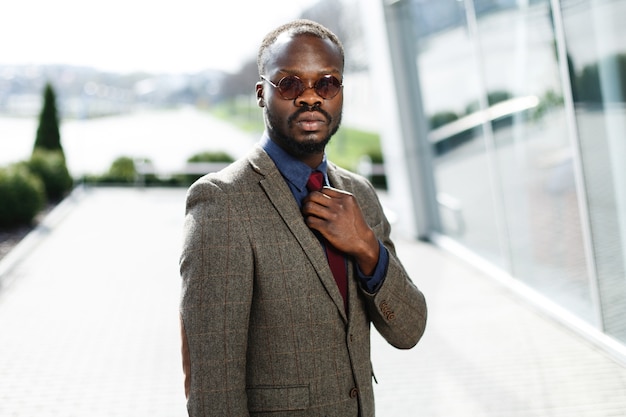 Elegante empresario negro afroamericano en gafas de sol redondas poses