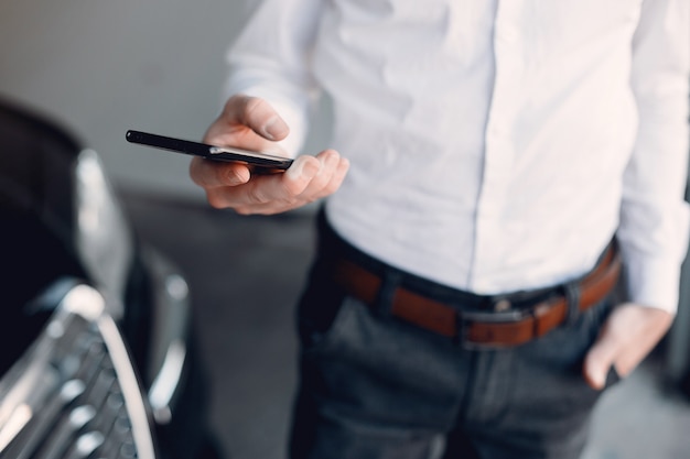 Elegante empresario trabajando cerca del coche