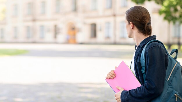 Elegante estudiante en el campus mirando a otro lado