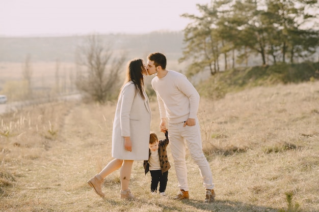 Elegante familia caminando en un campo soleado