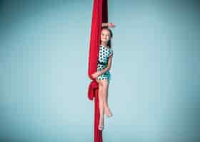 Foto gratuita elegante gimnasta sentada con telas rojas