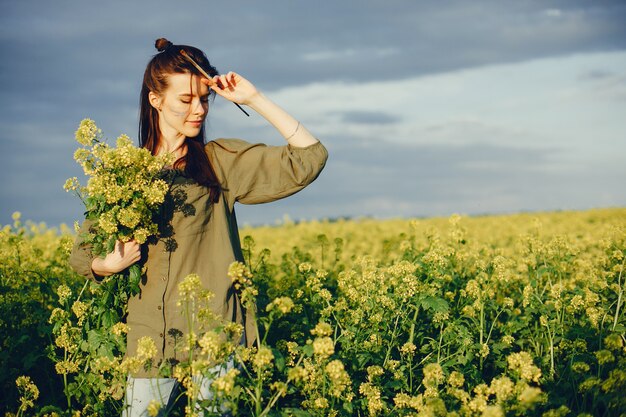 Elegante y hermosa niña pintando en un campo