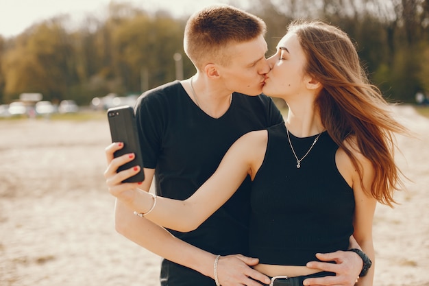 Foto gratuita una elegante y hermosa pareja vestida de negro pasa un buen rato en la playa