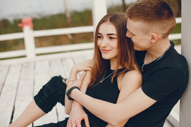 Una elegante y hermosa pareja vestida de negro pasa un buen rato en la playa