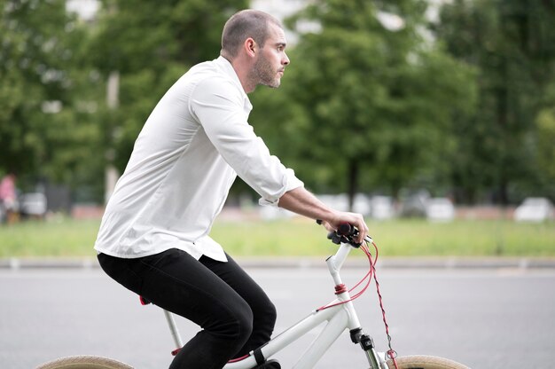 Elegante hombre adulto montando bicicleta al aire libre