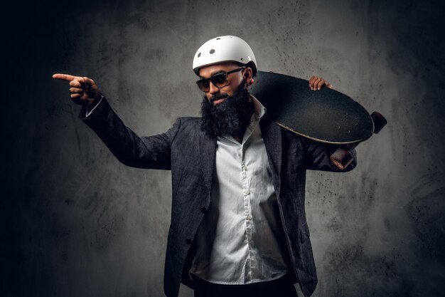 Un elegante hombre árabe vestido con un traje gris sostiene una tabla larga.