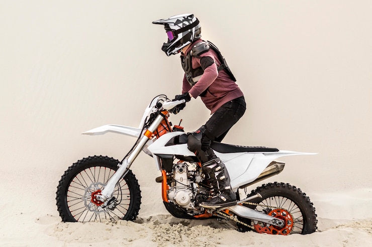 Foto gratuito elegante hombre montando moto en el desierto
