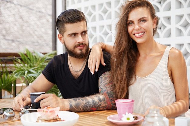 Elegante hombre y mujer sentada en la cafetería