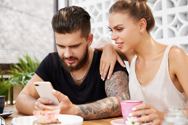 Elegante hombre y mujer sentada en la cafetería