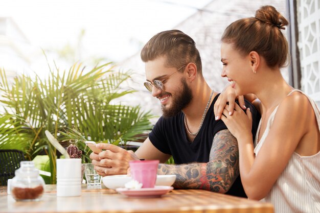 Elegante hombre y mujer sentada en la cafetería