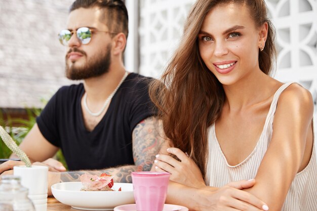 Elegante hombre y mujer sentada en la cafetería