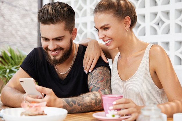 Elegante hombre y mujer sentada en la cafetería