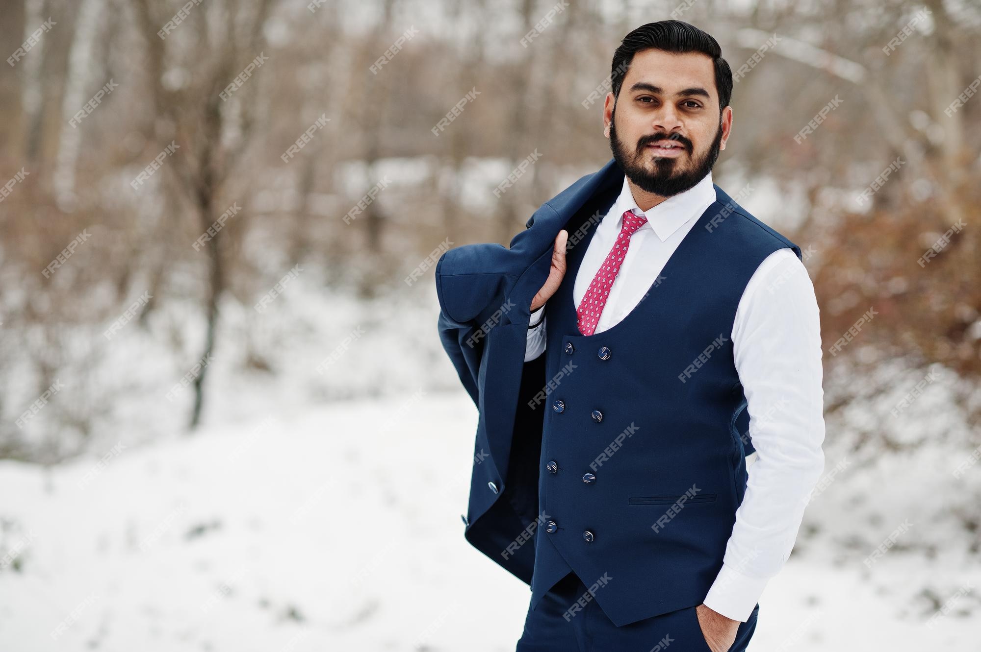 Elegante hombre de negocios de barba india con chaleco y traje posado en el de invierno al aire libre | Foto Gratis