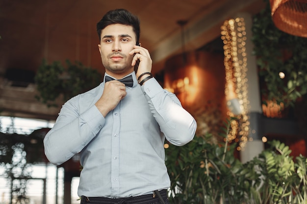 Elegante hombre de negocios en una camisa azul de pie interior