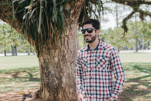 Elegante hombre sonriente posando en el parque