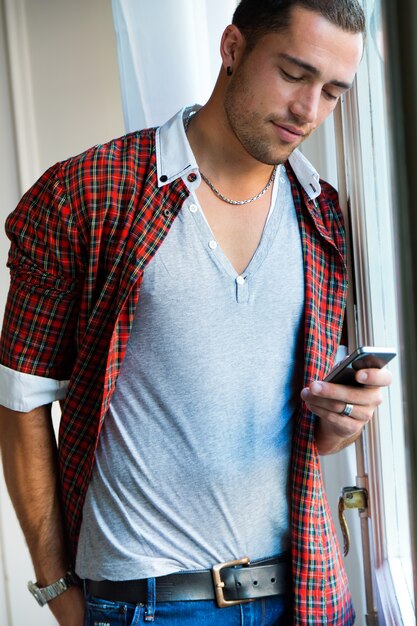 Elegante joven apuesto hombre con teléfono móvil.