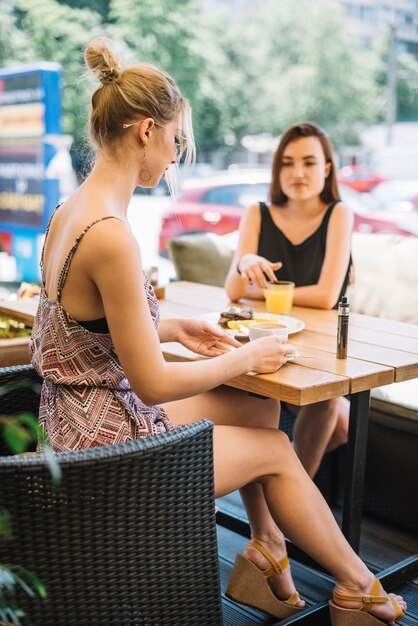 Elegante joven bebiendo café con su amiga