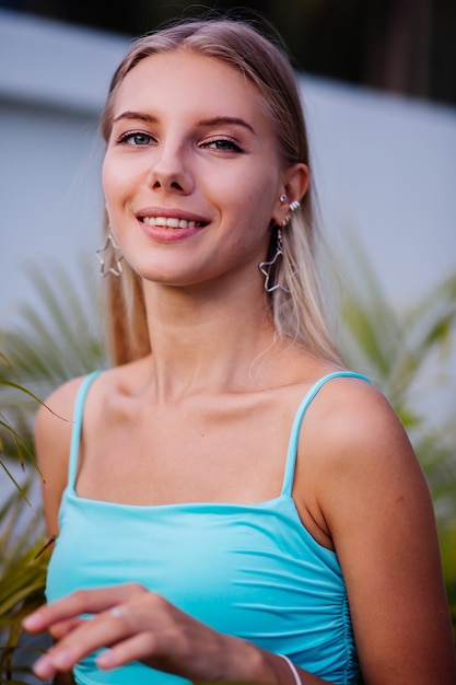Elegante joven y bella mujer rubia delgada en top de verano azul y falda corta