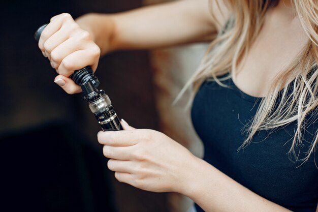 Elegante joven en una ciudad con vape