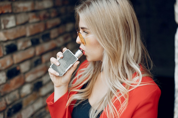 Elegante joven en una ciudad con vape