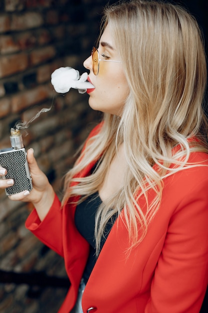 Foto gratuita elegante joven en una ciudad con vape