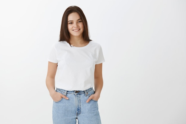 Foto gratuita elegante joven feliz posando contra la pared blanca