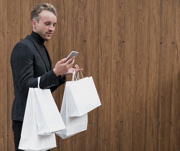 Foto gratuita elegante joven mirando smartphone