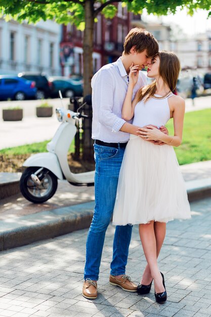 Elegante joven pareja de enamorados abrazándose, caminando en la vieja ciudad europea