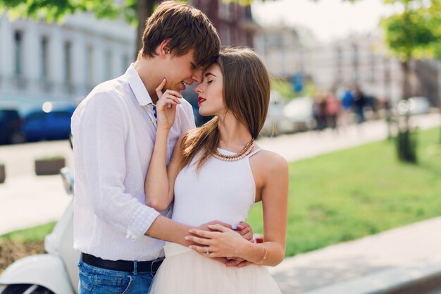 Elegante joven pareja de enamorados abrazándose, caminando en la vieja ciudad europea