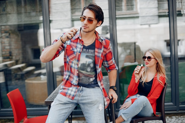 Elegante joven pareja con vape en un café