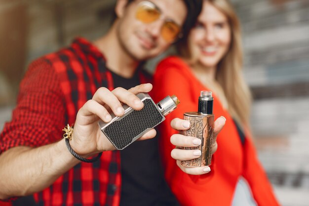 Elegante joven pareja con vape en una ciudad