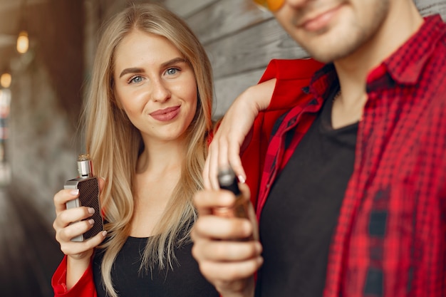 Elegante joven pareja con vape en una ciudad