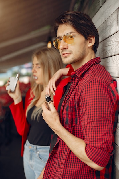 Elegante joven pareja con vape en una ciudad