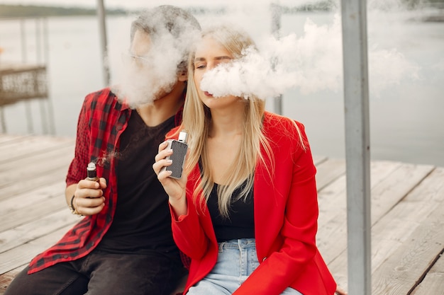 Elegante joven pareja con vape en una ciudad