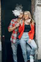 Foto gratuita elegante joven pareja con vape en una ciudad