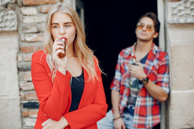 Foto gratuita elegante joven pareja con vape en una ciudad