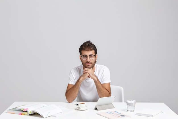 Foto gratuita elegante joven sentado en el escritorio