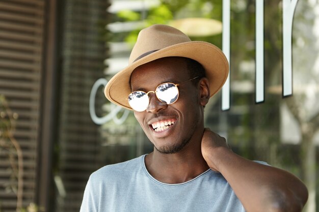 Elegante joven con sombrero y gafas de sol