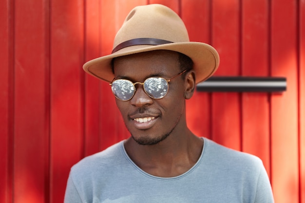 Elegante joven con sombrero y gafas de sol