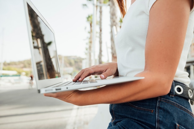 Elegante joven sosteniendo una laptop