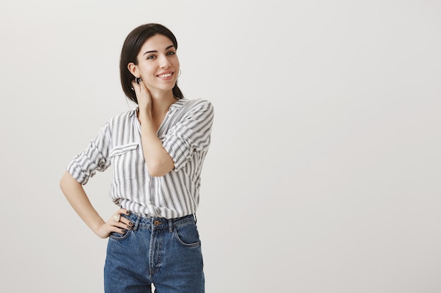 Elegante joven tocando el cuello y sonriendo