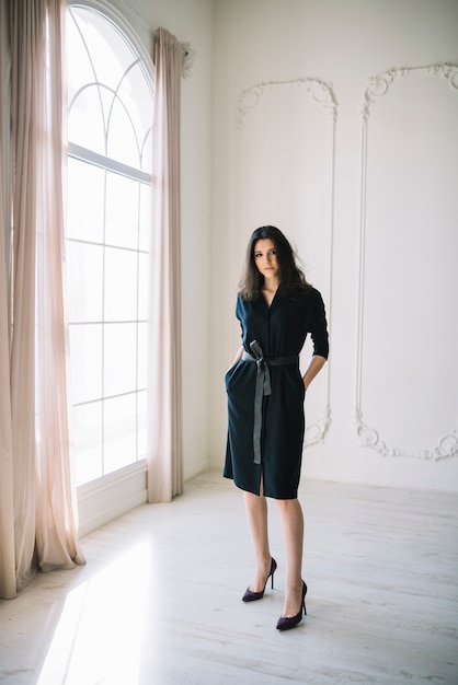 Elegante joven en vestido en la habitación