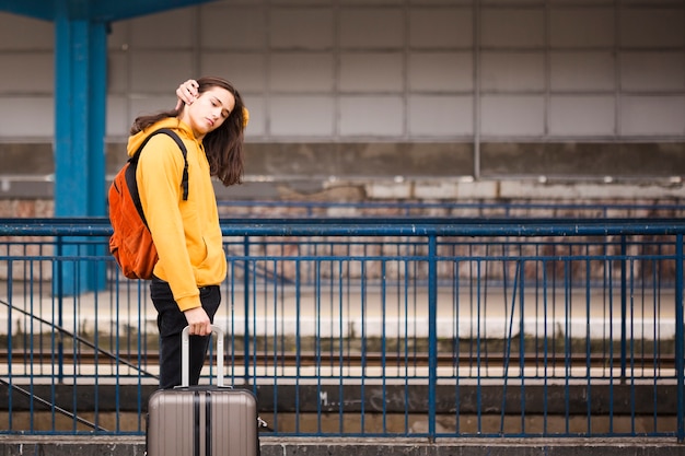 Elegante joven viajero en la estación de tren