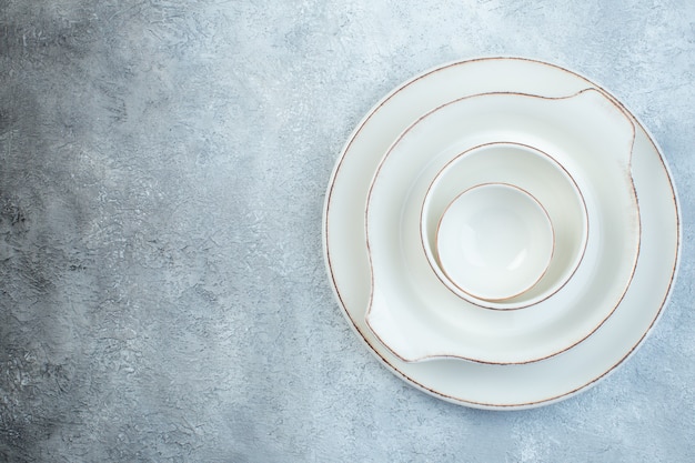 Elegante juego blanco vacío para cenar en el lado izquierdo sobre una superficie gris aislada con espacio libre