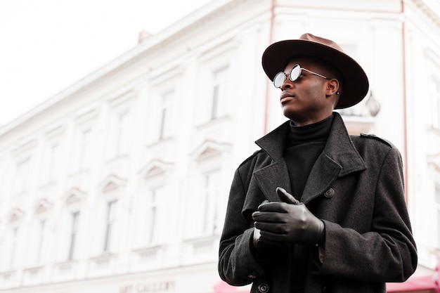 Foto gratuita elegante macho adulto con sombrero moderno y gafas de sol