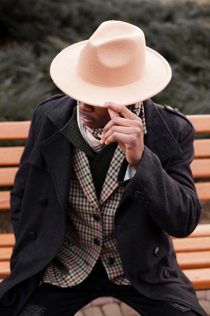 Elegante macho adulto con sombrero posando al aire libre