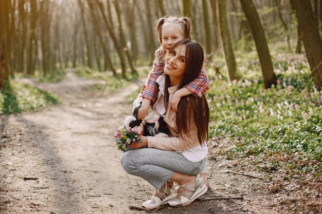 Elegante madre con hija en un bosque de verano